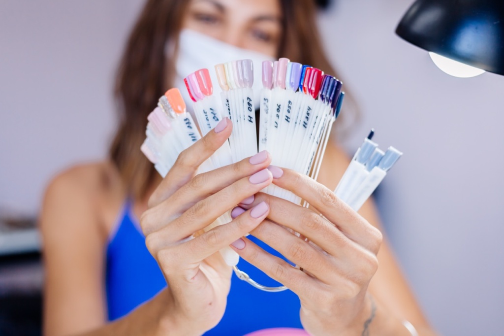 zensina-v-zasitnoi-medicinskoi-maske-v-salone-krasoty-poderzit-palitru-i-vyberet-cvet-procedura-manikura-uhod-za-nogtami-torzestvennoe-otkrytie-karantin-zakoncilsa-malyi-biznes-snova-otkryt&nbsp;— крупный размер.jpeg